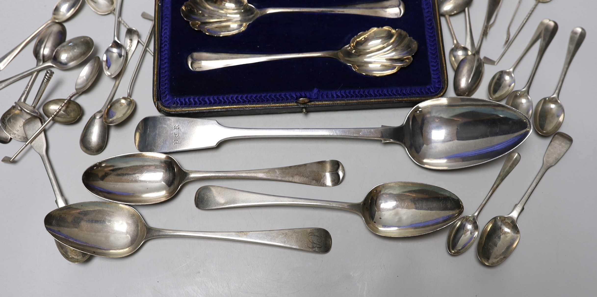 A Victorian Irish silver fiddle pattern basting spoon, Dublin, 1844, three George III tablespoons, a pair of later cased serving spoons and sundry tea, coffee and golf spoons, 23.7oz.